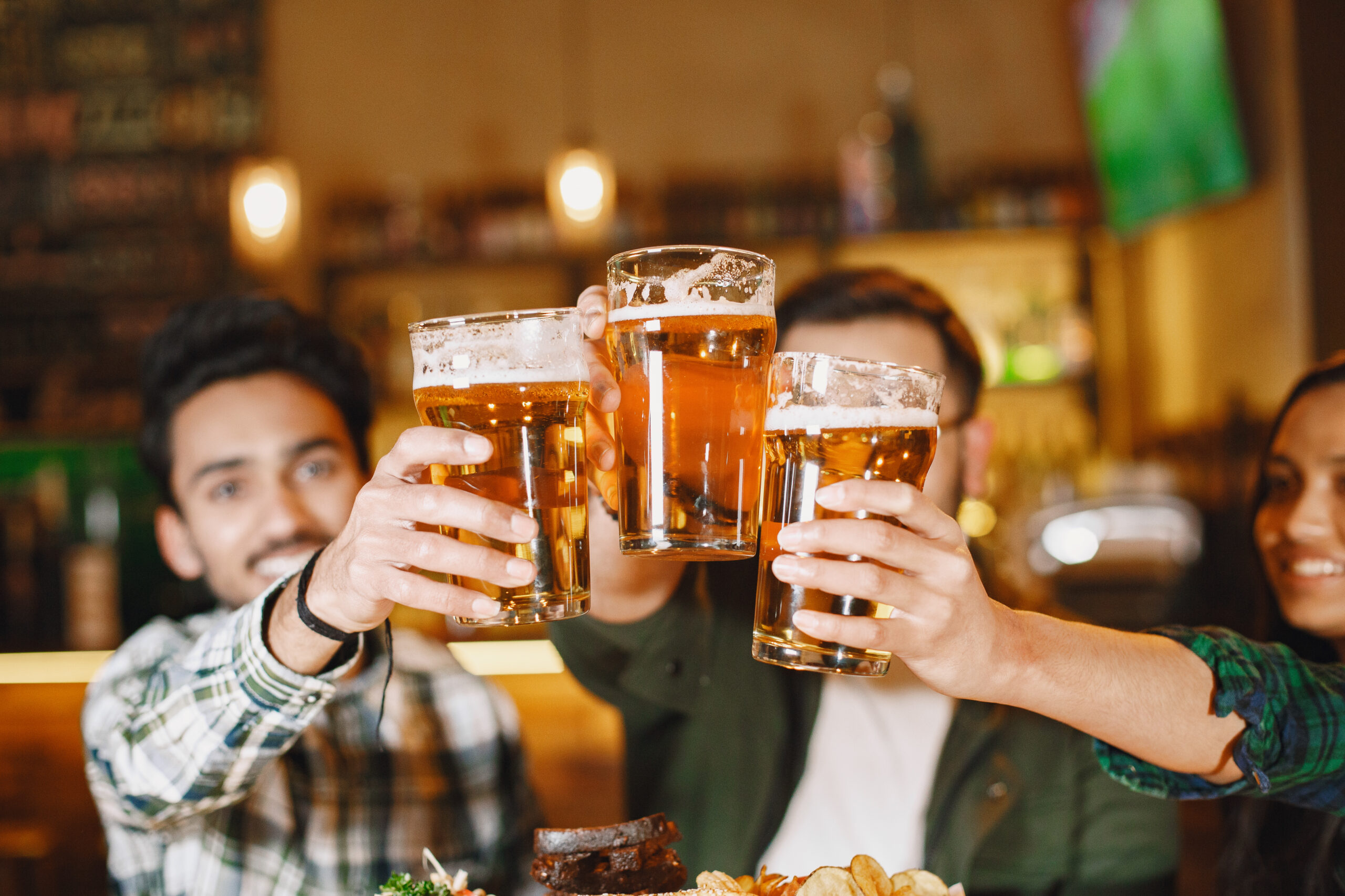 Indian friends celebrating in a pub with beer Excellent Venues for After-Work Drinks in Bristol